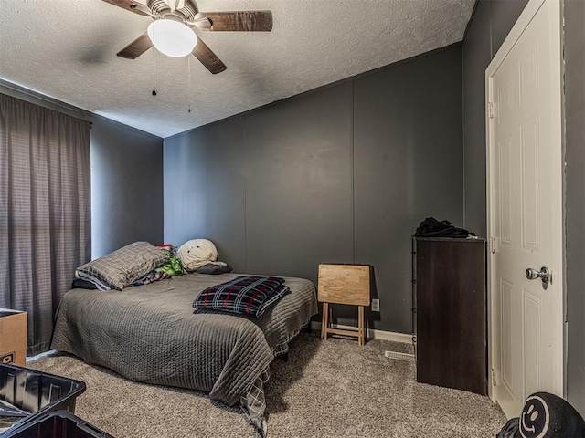 carpeted bedroom with ceiling fan and a textured ceiling