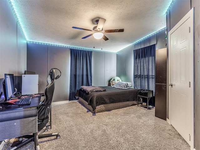 carpeted bedroom featuring ceiling fan and a textured ceiling