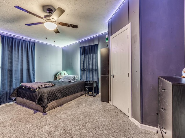 carpeted bedroom with ceiling fan and a textured ceiling