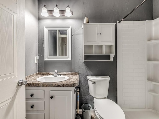 bathroom with vanity, toilet, and walk in shower