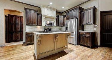 kitchen featuring a kitchen island, appliances with stainless steel finishes, tasteful backsplash, sink, and light hardwood / wood-style flooring