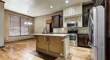 kitchen with sink, a kitchen bar, dark brown cabinetry, stainless steel appliances, and a center island with sink