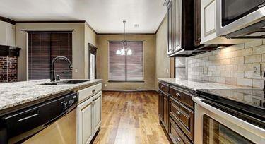 kitchen featuring appliances with stainless steel finishes, sink, hanging light fixtures, crown molding, and dark brown cabinets