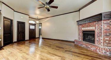 unfurnished living room with a brick fireplace, ornamental molding, light hardwood / wood-style floors, and ceiling fan