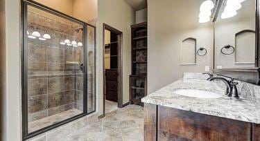 bathroom featuring a shower with door, vanity, and a chandelier