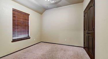 unfurnished room featuring lofted ceiling and light colored carpet