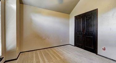 unfurnished bedroom featuring lofted ceiling