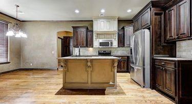 kitchen featuring light hardwood / wood-style flooring, dark brown cabinets, stainless steel appliances, a kitchen island, and a kitchen bar