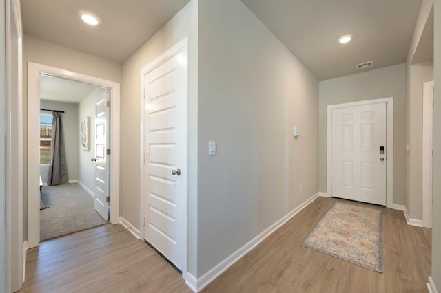 hallway featuring recessed lighting, baseboards, visible vents, and light wood finished floors