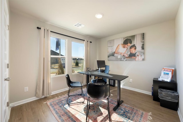 office area featuring wood finished floors, visible vents, and baseboards