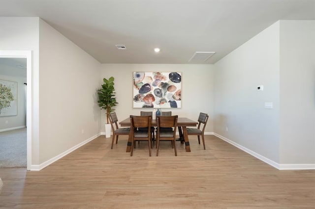 dining room featuring light wood-style floors, visible vents, and baseboards