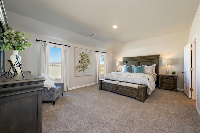 bedroom featuring baseboards, multiple windows, visible vents, and light colored carpet