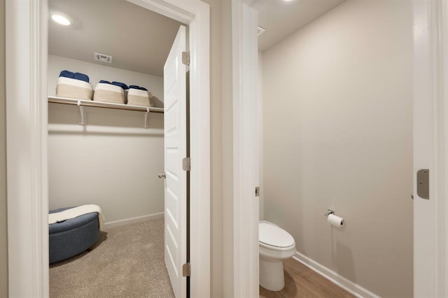 bathroom featuring toilet, baseboards, and visible vents