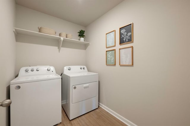 clothes washing area featuring light wood-type flooring, laundry area, baseboards, and separate washer and dryer