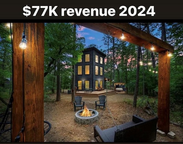 playground at dusk with an outdoor fire pit and a wooden deck