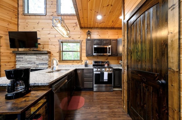 kitchen featuring appliances with stainless steel finishes, dark wood-type flooring, a sink, light stone countertops, and wooden ceiling