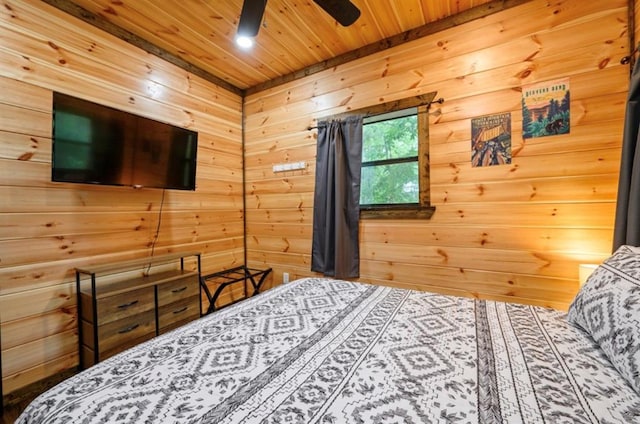 bedroom featuring wooden ceiling, wooden walls, and a ceiling fan