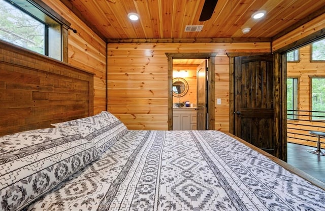 bedroom featuring wood walls, wood ceiling, multiple windows, and visible vents