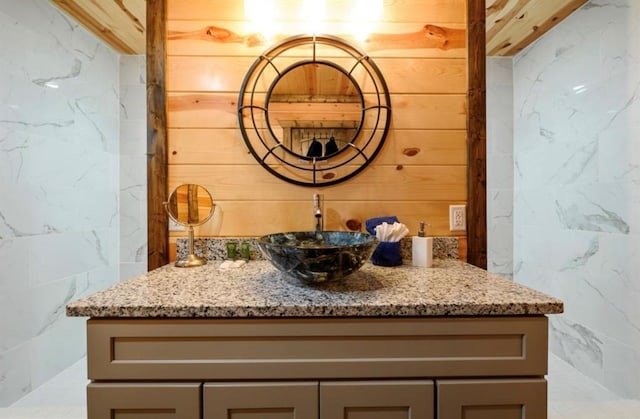 bathroom featuring wooden walls and vanity