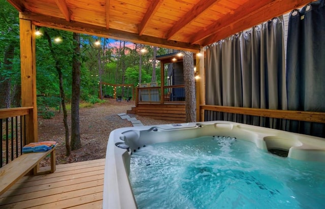 deck at dusk with an outdoor hot tub