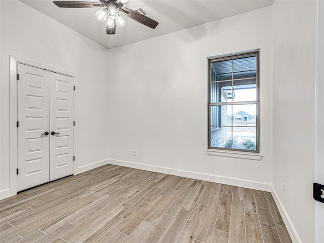 spare room with ceiling fan and light wood-type flooring