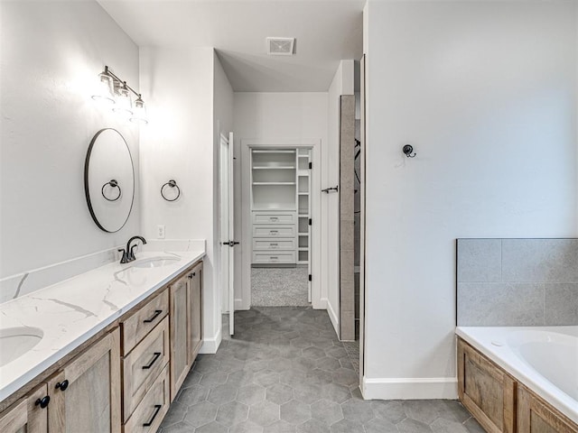 bathroom featuring vanity and tiled bath