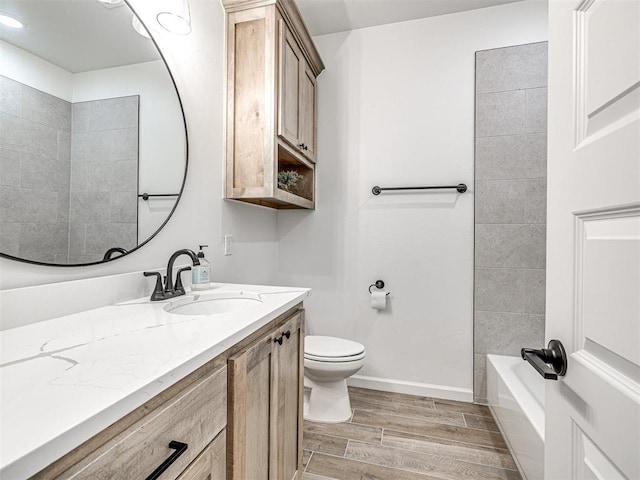 full bathroom featuring vanity, tiled shower / bath, and toilet