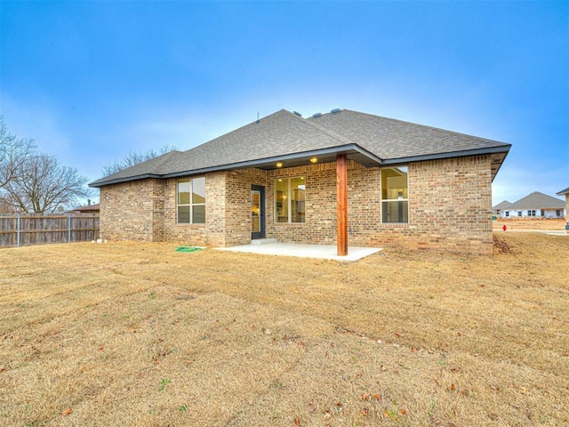 rear view of house featuring a yard and a patio