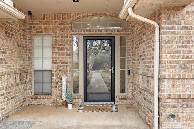 doorway to property featuring brick siding