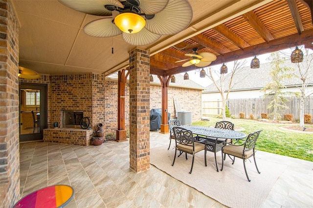 view of patio with an outdoor brick fireplace, area for grilling, ceiling fan, and central air condition unit