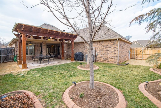 rear view of property with ceiling fan, a pergola, a patio, and a lawn