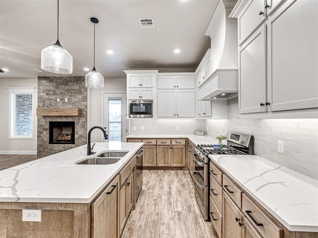 kitchen with stainless steel appliances, sink, white cabinets, and a spacious island