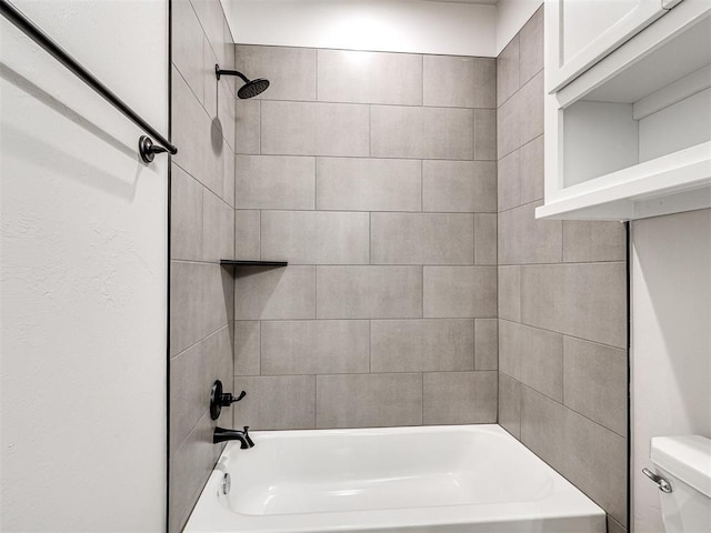 bathroom with tiled shower / bath combo and toilet