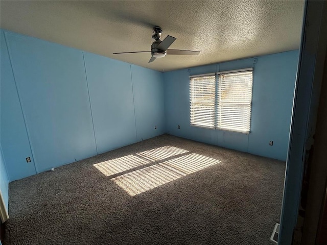 carpeted spare room with ceiling fan and a textured ceiling