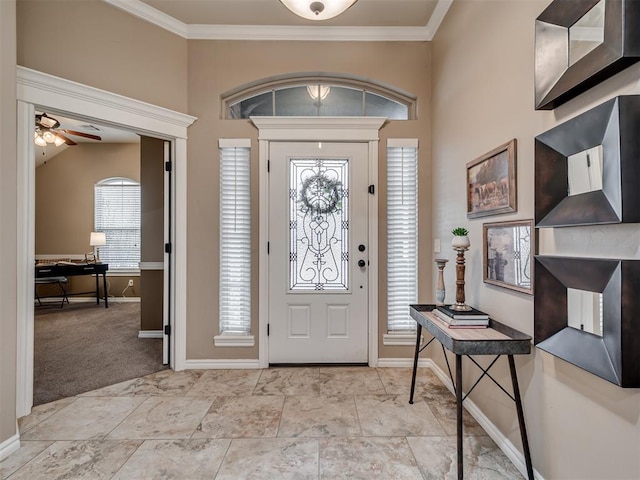 entrance foyer featuring light colored carpet, ceiling fan, ornamental molding, and vaulted ceiling