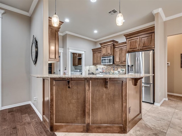 kitchen with light stone counters, ornamental molding, appliances with stainless steel finishes, kitchen peninsula, and decorative backsplash