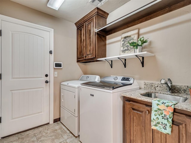 washroom with cabinets, sink, and washer and clothes dryer