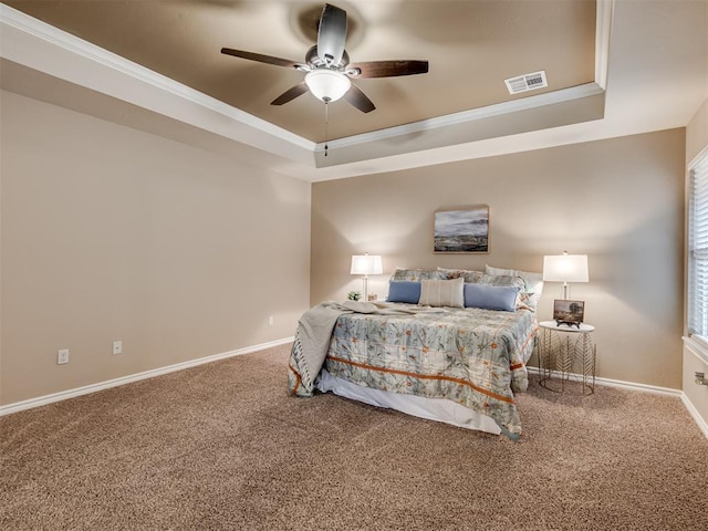 carpeted bedroom featuring crown molding, ceiling fan, and a tray ceiling