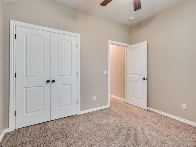 unfurnished bedroom with ceiling fan, a closet, and light carpet