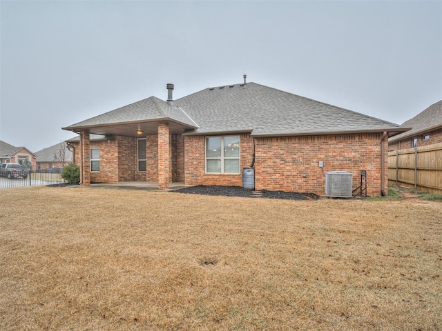 back of house with a patio area, central AC, a water view, and a lawn