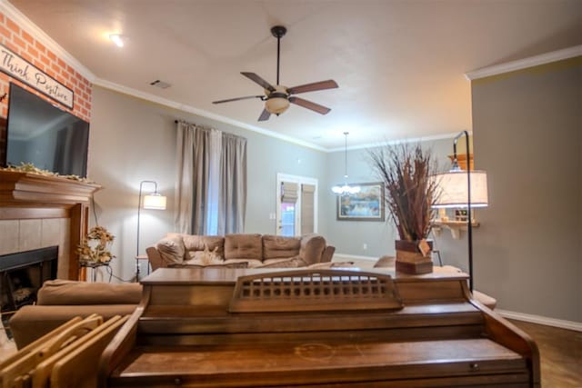 living room with crown molding, ceiling fan, and a fireplace