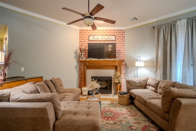 living room with crown molding, a brick fireplace, and ceiling fan