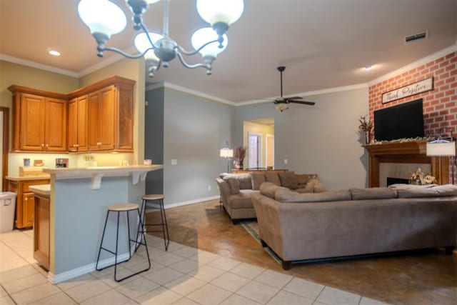 living room featuring crown molding, a large fireplace, light tile patterned flooring, and ceiling fan with notable chandelier