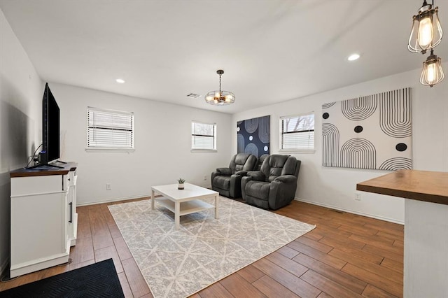 living room with an inviting chandelier and light wood-type flooring