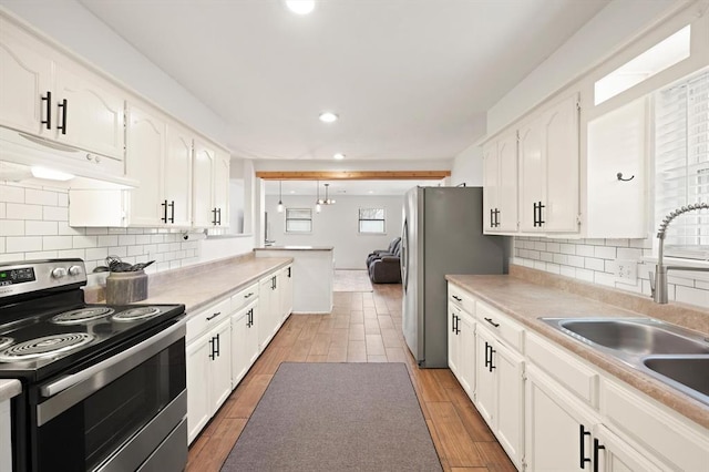 kitchen with backsplash, stainless steel appliances, sink, and white cabinets