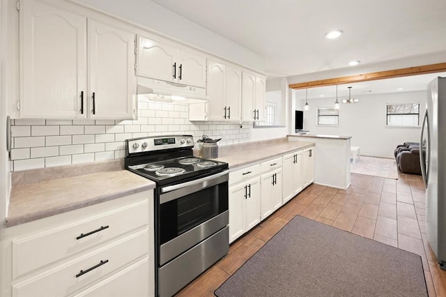 kitchen with pendant lighting, backsplash, white cabinets, and appliances with stainless steel finishes