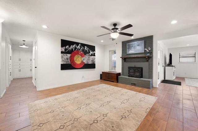 unfurnished living room with hardwood / wood-style floors, a fireplace, and ceiling fan