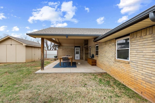 rear view of house with a patio, a yard, and a storage shed