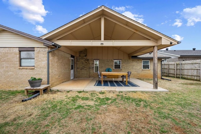 rear view of property featuring a patio and a lawn