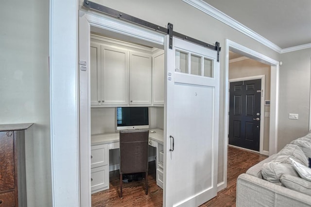 office featuring a barn door, ornamental molding, and dark hardwood / wood-style flooring